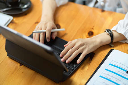 Top view, close-up of female hands typing on digital tablet keyboard. working at office.の写真素材