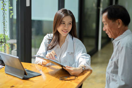 Young female doctor showing a medicine prescription to middle-aged male patient. doctor consulting with patient.の写真素材