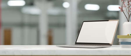 Laptop computer blank screen mockup on marble white table with decor over blurred library room in background. 3d rendering, 3d illustrationの写真素材
