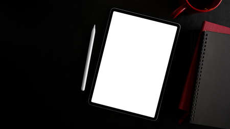 Digital portable wireless tablet computer with white screen display on black background. top view, flat layの写真素材