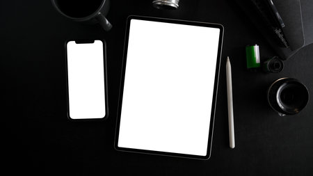Top view of smartphone and tablet with white screen display and open notebook on black background. top view, flat layの写真素材