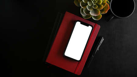 Smartphone white screen mockup on black background, black desk concept. wireless device. mobile phone.の写真素材