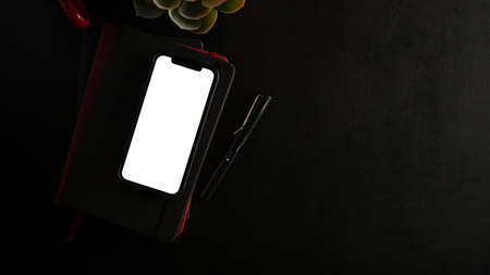 Modern smartphone white display mockup for montage your graphic and copy space on black background. top view, flat layの写真素材