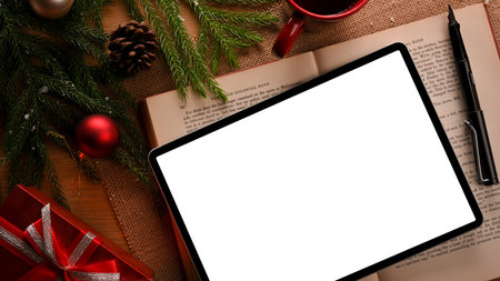 Top view, Digital laptop computer white screen mockup on table decorated with Christmas theme. Special holiday, celebrations. flat layの写真素材