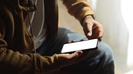 A man chatting on smartphone application, using mobile phone. smartphone blank screen mockup. cropped image.の写真素材