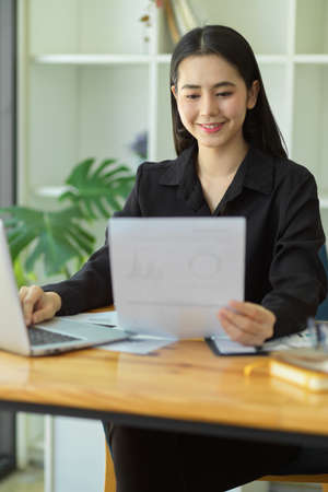 Portrait of Positive businesswomen looking at financial report and satisfied with the company financial's result.の写真素材