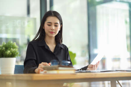 Attractive young businesswoman working with her assignment at the co working space of coffee shop.の写真素材