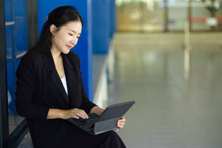 A successful asian female manager working on digital tablet computer at the office.の写真素材
