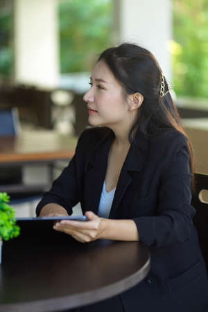Portrait of a businesswoman sitting at the desk while talking with her business client at coffee shop.の写真素材