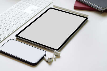 Close-up devices on the table with keyboard, tablet computer and smart mobile phone blank screen...