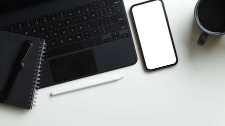 Top view image simple workspace with digital tablet computer, diary and smartphone blank screen mockup on white background.の写真素材