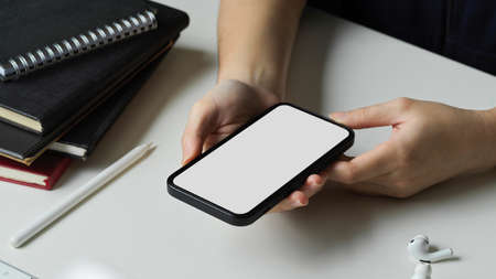 Close-up, Female using smartphone, chatting with her friends, scrolling on shopping application. mobile phone blank screen mockup.の写真素材
