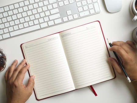 Top view, Blank pages in diary book on modern worktable. a man's hands with a book. study conceptの写真素材
