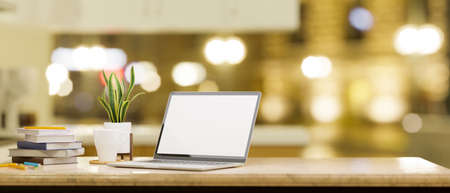 Close-up, white screen laptop computer with copy space on working table over blurred yellow bokeh light in the background. 3d rendering, 3d illustrationの写真素材