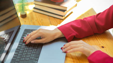 Cropped, close-up image of a female hands typing on laptop keyboard, working on laptop computer.の写真素材