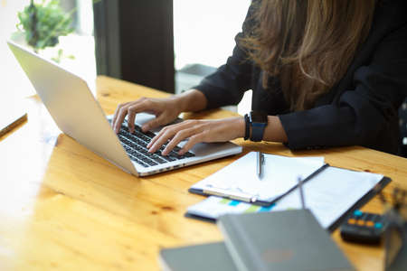 Close-up image of businesswoman using laptop computer doing her assignment at the office.の写真素材