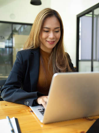 Portrait of an asian young business woman working on laptop computer in the office workplace. female worker using notebook.の写真素材