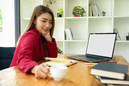 Beautiful and cheerful female entrepreneur or business owner working at her modern office.の写真素材