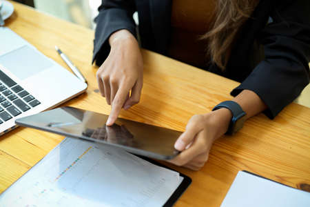 Cropped image of female employee or business women using digital tablet computer at her desk.の写真素材