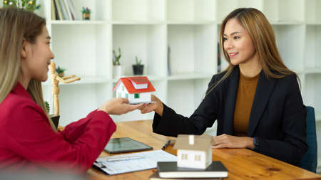 Asian female real estate agent meets with her client to finalize a rental agreement at the office.の写真素材