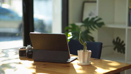 Digital touchpad tablet computer and camera on a table in co-working space. freelance photographer equipment concept.の写真素材