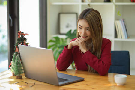Business woman having an online meeting with strategy team via laptop computer. Female entrepreneur using computer notebook.の写真素材