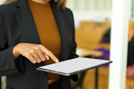 Cropped shot of an attractive business woman or female employee using portable digital tablet computer or touchpad.の写真素材