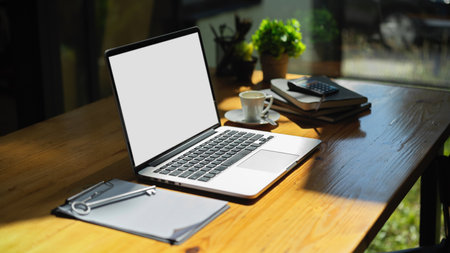 Laptop computer notebook white screen mockup and office supplies on the table in office workplace.の写真素材
