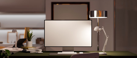 Modern home office workspace with a computer mockup under light from table lamp on a working desk. Home interior concept. 3d rendering, 3d illustrationの写真素材