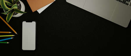 Modern dark workspace with laptop, stationery, smartphone blank screen and copy space on black leather background. Top view, flat lay. 3d rendering, 3d illustrationの写真素材