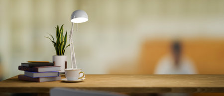 Simple wooden table with office supplies and copy space for product display over blurred office...