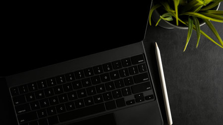 Modern tablet computer with keyboard and stylus pen on dark workspace. black background. top viewの写真素材