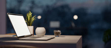 Close-up side view, A simple workspace at home with laptop computer, wireless speaker, coffee cup and plant in a pot on table. 3d rendering, 3d illustrationの写真素材