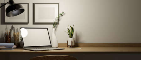 Close-up, An artist designer working desk with laptop computer mockup, painting tools, decors, blank poster frame on wall and copy space on wooden table. 3d rendering, 3d illustrationの写真素材