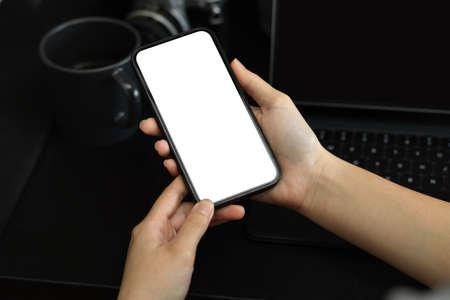 Close-up, a female hands holding smartphone blank screen mockup for display your graphic banner.の写真素材