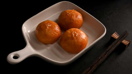 Homemade Chinese fried buns on a plate and chopsticks on dining table. Asian street food concept.の写真素材