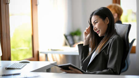 Creative marketing officer is thinking her new creative ideas for her project. An asian business woman is happy with her work's result.の写真素材