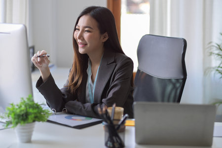 Friendly female manager having an online meeting with her colleagues on her computer. A business woman joined a webinar conference.の写真素材