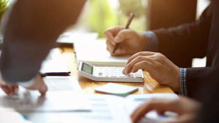 A team of male accountants calculating their company profit and income. Businessmen meeting and...