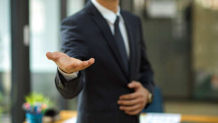 Businessman stretch hand for handshake greeting his partners in the meeting. Male CEO hand welcome newcomer.の写真素材