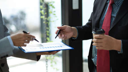Close-up image of Two CEO or executive manager standing in the office and having a small talk about their financial work.の写真素材