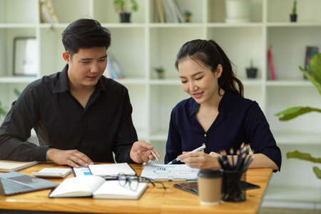 Two of young financial trainees working together in the modern office workplace. teamwork....
