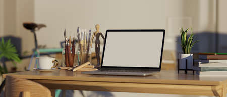 Wooden working table with laptop computer mockup, painting tools, coffee cup and accessories on blurred living room background. 3d rendering, 3d illustrationの写真素材
