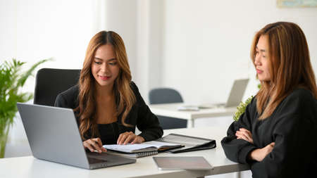 Asian female insurance consultant discussing with her potential client in the office workplace.の写真素材
