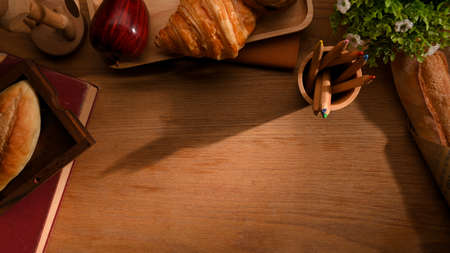 A vintage workspace background with copy space, stationery, decor, pastry book and a tray of baked bread. Top viewの写真素材