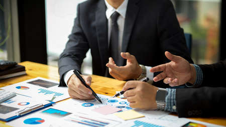 Close-up image of a Male executive manager in formal suit talking with his financial analysts at the...