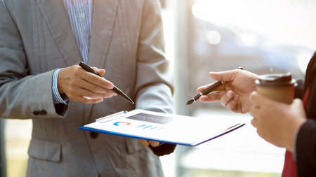 Close-up image of a Male financial analysts talking the financial work with a female manager in the office.の写真素材