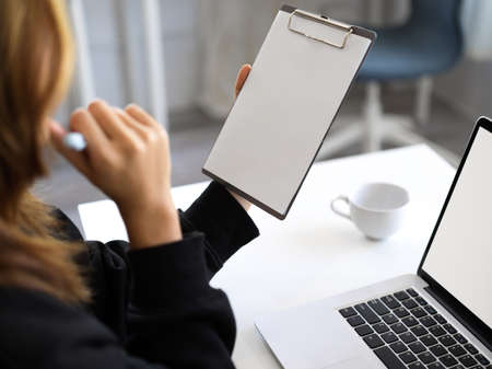 A female officer reading an informations on a clipboard paper. Woman holding a blank clipboard paper...
