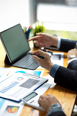 Cropped and focused image of a businessman's hands holding a pen and pointing at a tablet touchpad...
