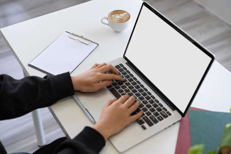 Close-up image, A woman working on laptop computer, typing on notebook computer keyboard on a modern workspace. laptop blank screen mockupの写真素材